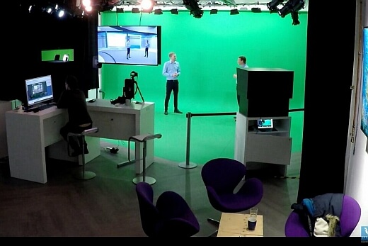 Nikolaus Meissner und Ken Blöcker vom UVUW (Unternehmensverband Unterweser) im Green Screen Studio in Hamburg-Halstenbek. Man sieht die grüne Wand, im Bildschirm oben den digitalen Hintergrund, die Kameras und Beleuchtung.